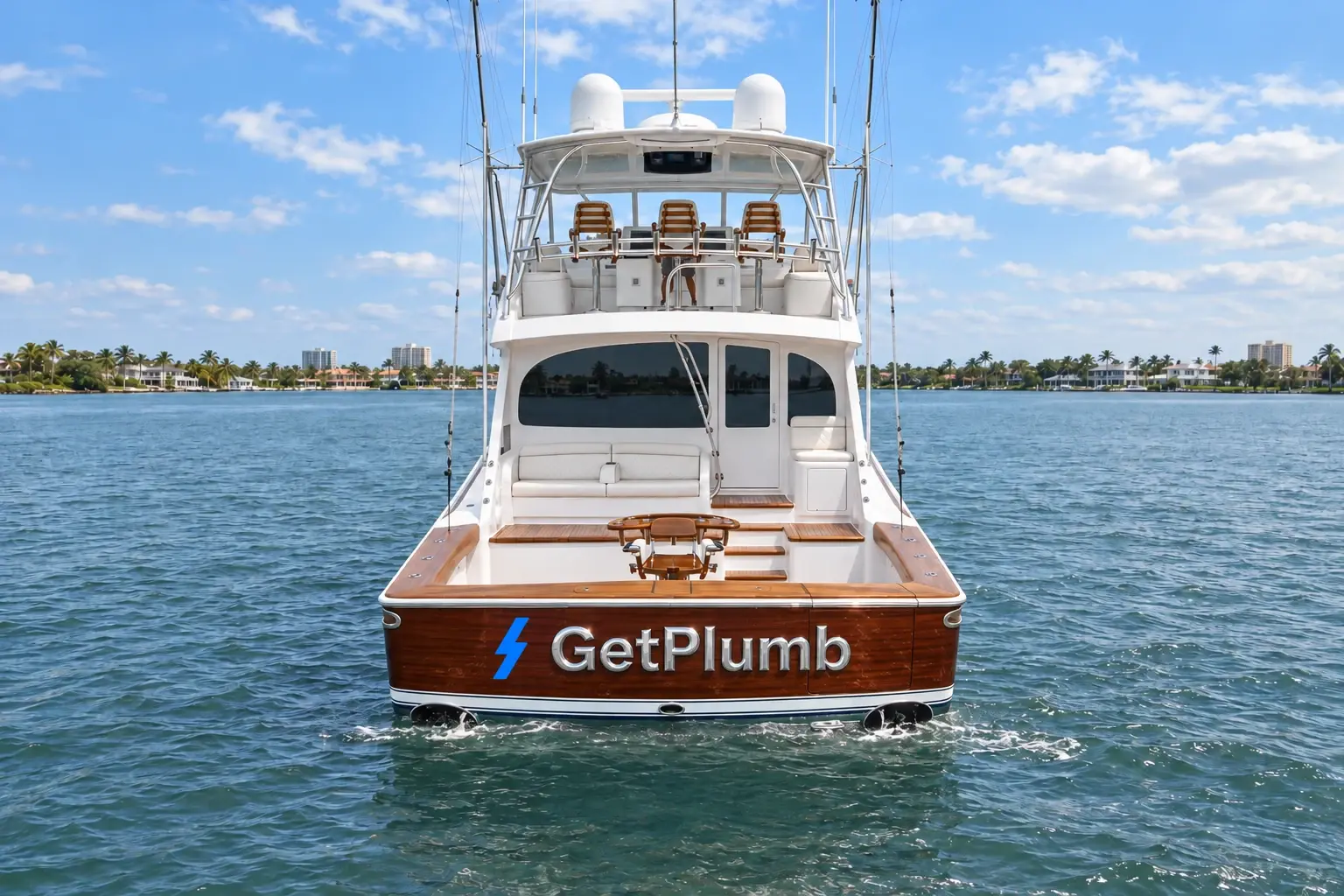 Yacht in laguna visto da poppa, con specchio in mogano lucido, lettere metalliche GetPlumb e simbolo Plumb blu.